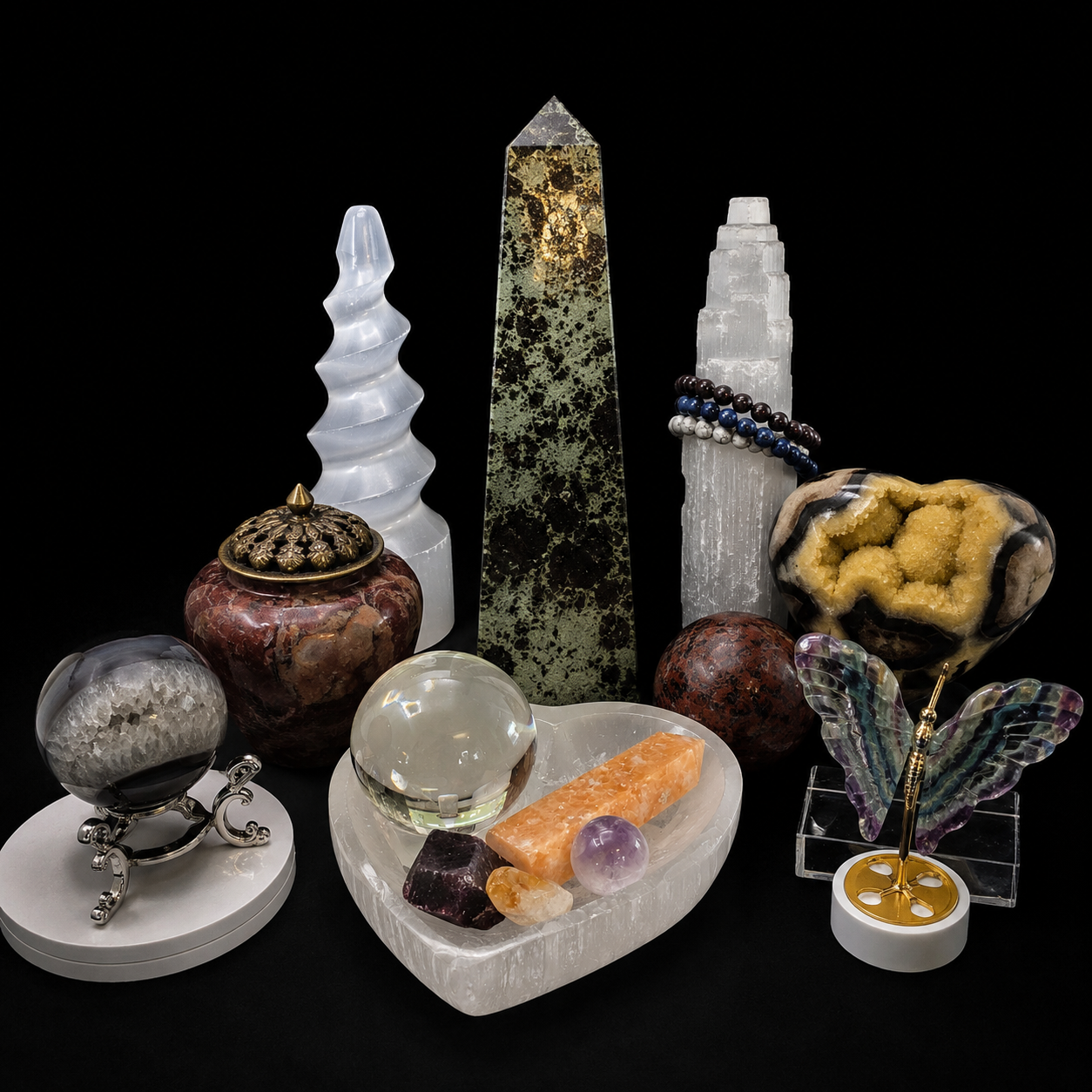 Crystal carvings, towers, spheres, and polished mineral decor displayed on black background