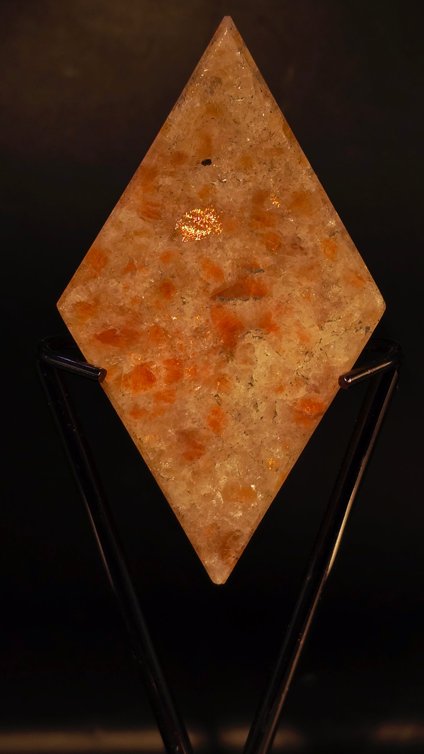 Square stone with orange and brown hues on a black background