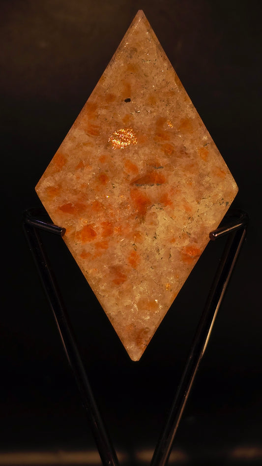 Square stone with orange and brown hues on a black background